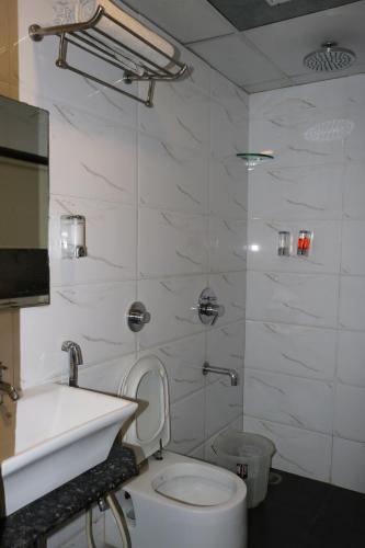 a bathroom with a white toilet and a sink at Hotel Raj in Aurangabad