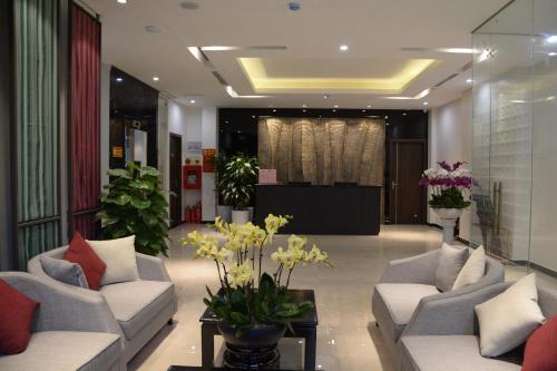 a lobby with couches and flowers in a building at Max Boutique Hotel in Cao Bằng