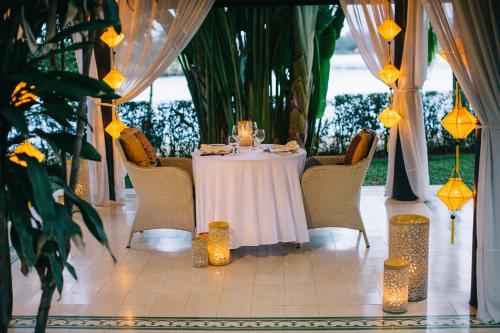 a table with a white table cloth and candles on it at Anantara Hoi An Resort in Hoi An