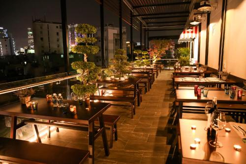 胡志明市The Umi Hotel的餐厅的一排桌子,享有城市美景