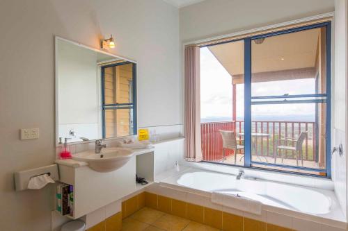 a bathroom with a tub and a sink and a window at Bimbadeen Estate in Mount View