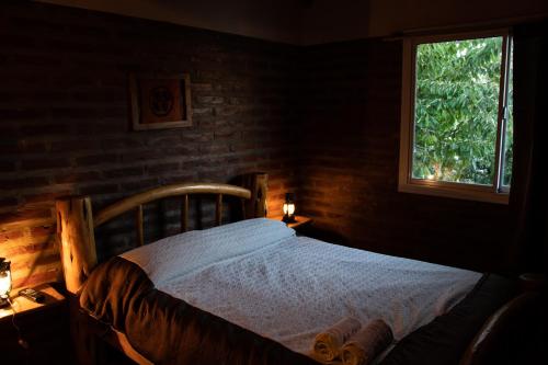 1 dormitorio con cama de madera y ventana en Patagonia Retro en Esquel