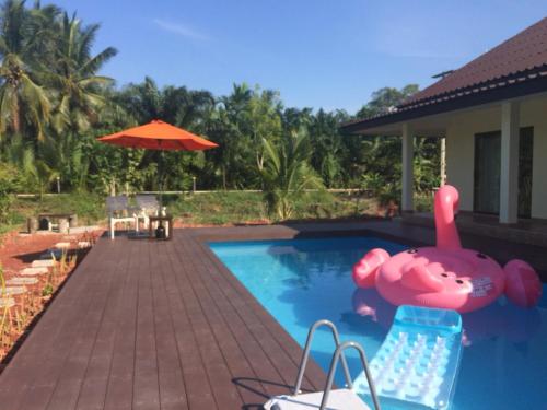 uma piscina com um porco insuflável numa casa em Bangsrai Cottage em Surat Thani