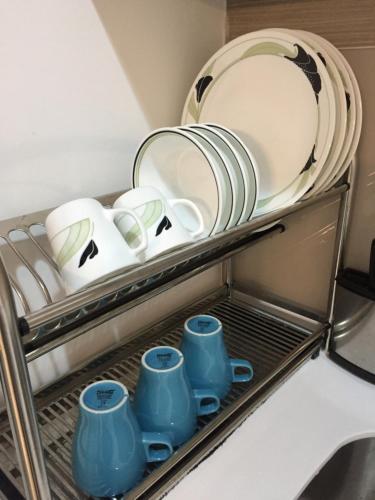 a shelf filled with plates and cups and dishes at Emira Residence Sek 13 Shah Alam Wi-Fi Netflix in Shah Alam