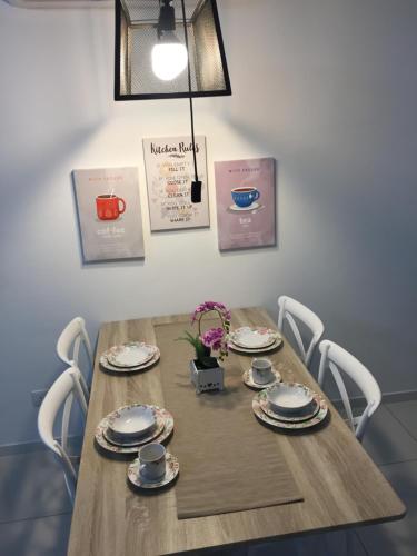 a wooden table with plates and dishes on it at Emira Residence Sek 13 Shah Alam Wi-Fi Netflix in Shah Alam