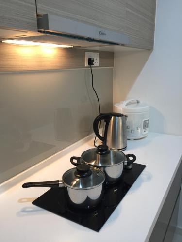 a couple of pots and pans on a stove top at Emira Residence Sek 13 Shah Alam Wi-Fi Netflix in Shah Alam
