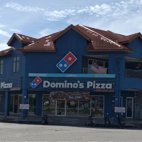 a blue building with a dominoes pizza sign on it at AsSalam Homestay in Seri Iskandar