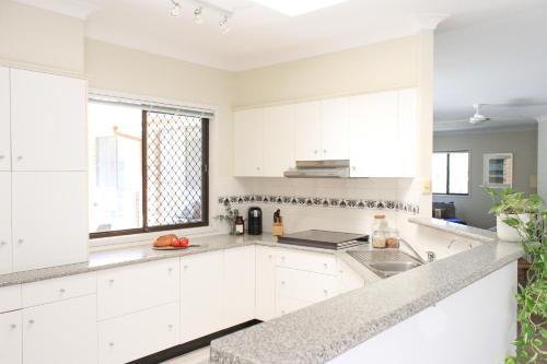 a white kitchen with a sink and a window at Away on Massinger Street in Byron Bay