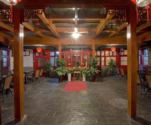 a large room with tables and chairs and a red rug at Qianmen Courtyard Hotel in Beijing