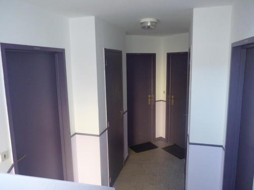 an empty room with three doors and a hallway at Résidence Honoré de Balzac in Brest