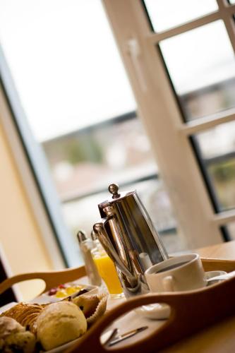 a plate of food with a tea kettle and bread at Talbot Hotel Stillorgan in Stillorgan