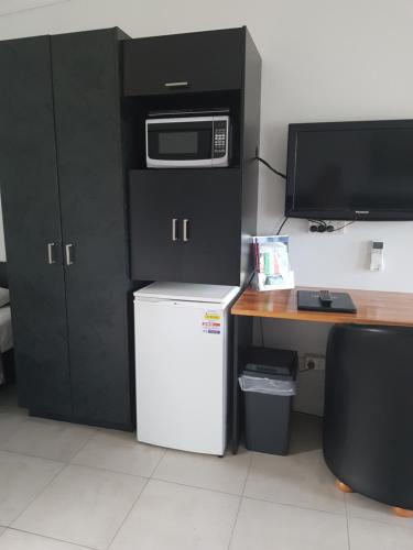 a kitchen with a microwave, refrigerator, and dishwasher at Sunseeker Motel in Hervey Bay