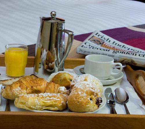 a tray with pastries and a cup of orange juice at Talbot Hotel Stillorgan in Stillorgan