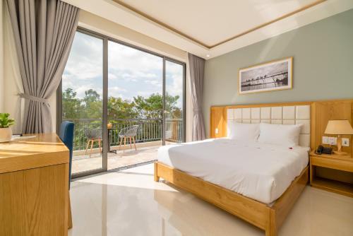 a bedroom with a bed and a balcony at Babylon Hoi An Central Villa in Hoi An