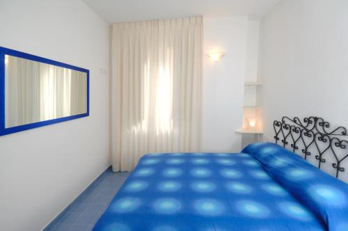 a bedroom with a blue bed and a window at Aurora Apartments in Amalfi
