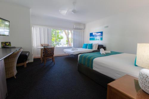 a hotel room with a bed and a desk at Sonia's At Ramada Resort Free Wifi in Port Douglas