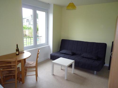 a living room with a blue couch and a table at Résidence Honoré de Balzac in Brest