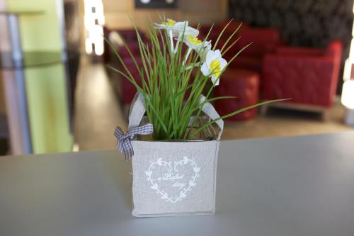 a vase with flowers in it sitting on a table at Hotel Los Pasiegos in Hoznayo