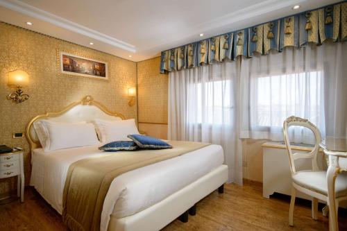 a bedroom with a bed and a chair and a window at Hotel Olimpia Venice, BW Signature Collection 3sup in Venice