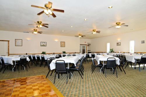 a banquet hall with white tables and black chairs at SureStay Plus Hotel by Best Western Berkeley Springs in Berkeley Springs