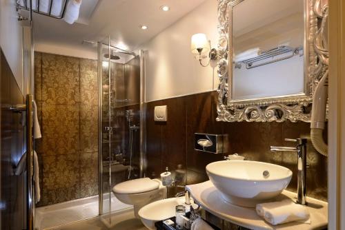 a bathroom with a sink and a toilet and a shower at Hotel Olimpia Venice, BW Signature Collection in Venice