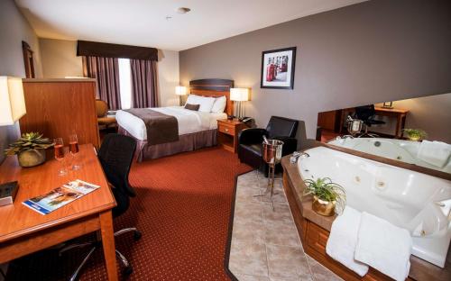 Best Western Plus Moncton في مونكتون: غرفة في الفندق مع سرير وحوض استحمام