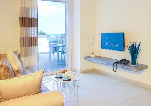 a living room with a couch and a tv on a wall at Villa Caruso in Ischia