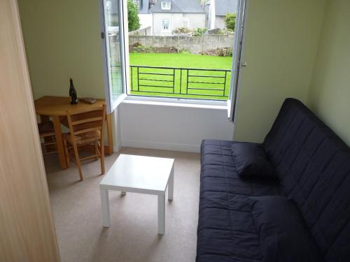 a living room with a couch and a table and a window at Résidence Honoré de Balzac in Brest