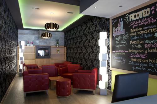 a restaurant with red chairs and a chalkboard at Hotel Los Pasiegos in Hoznayo