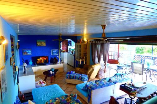 uma sala de estar com paredes azuis e sofás em Villa Vaiana EURL Vaiana Faratea officedu tourisme 1593DTO MT em Paopao
