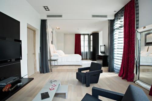 uma sala de estar com um sofá e um quarto com uma cama em Domaine de Verchant & Spa - Relais & Châteaux em Montpellier