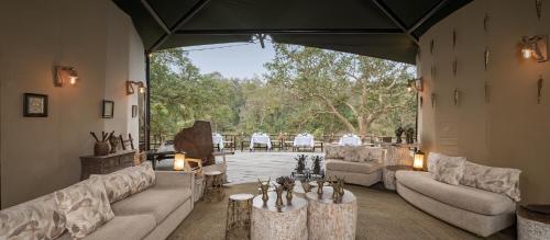 a large living room with couches and a patio at Banjaar Tola Kanha National Park - A Taj Safari Lodge in Kānha