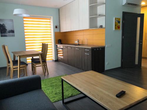 a kitchen and dining room with a table and a couch at Poilsio apartamentai "Jolita" in Druskininkai