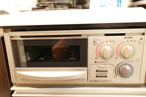a microwave oven with a person inside of it at IBASHO ShibuyaDogenzaka907 in Tokyo