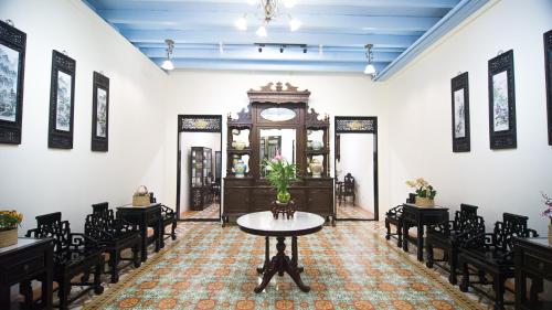 a room with a table and chairs and a clock at WOO Gallery & Boutique hotel in Phuket Town
