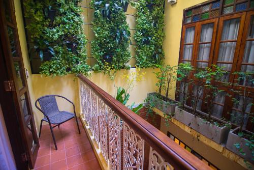 a balcony with a chair and plants on a wall at WOO Gallery & Boutique hotel in Phuket Town