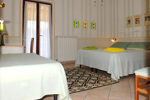 a bedroom with two beds with white sheets and yellow towels at La Casa Del Sole in Bomarzo