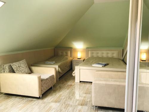 a room with two beds and a couch in it at Hotel Aragvi in Mtskheta