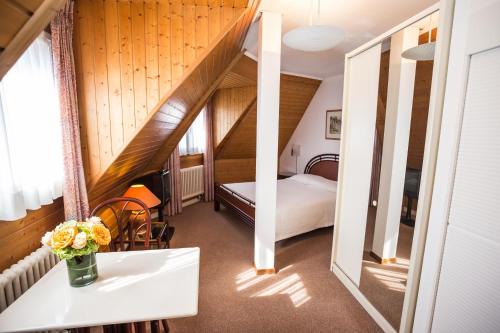 日內瓦的住宿－塞特維丁住宅酒店，一间设有一张床和一张花瓶桌子的房间