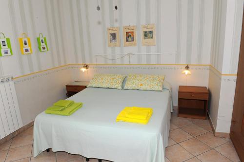 a bedroom with a white bed with yellow towels on it at La Casa Del Sole in Bomarzo