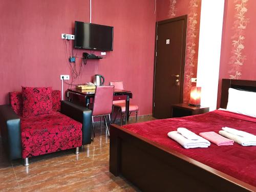 a bedroom with a bed and a chair and a desk at Hotel Aragvi in Mtskheta