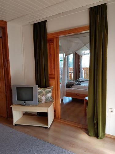 a living room with a tv and a bedroom at Kaktusz Villa Heviz in Hévíz