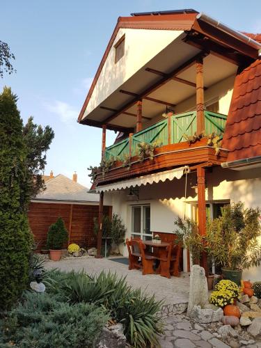 a house with a balcony with a table and chairs at Kaktusz Villa Heviz in Hévíz
