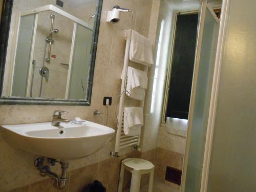 a bathroom with a sink and a mirror and a shower at Hotel Giglio in Florence