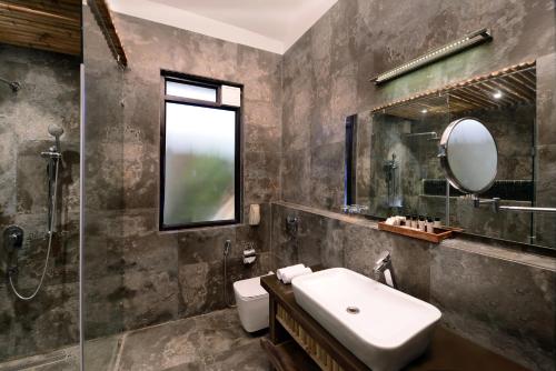 y baño con lavabo y espejo. en Shri Radha Brij Vasundhara Resort & Spa, en Govardhan