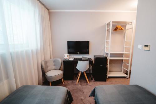 a bedroom with a desk and a tv and a bed at Penzion Set in Košice