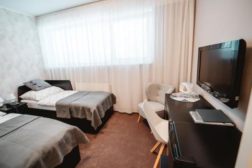 a hotel room with a bed and a flat screen tv at Penzion Set in Košice