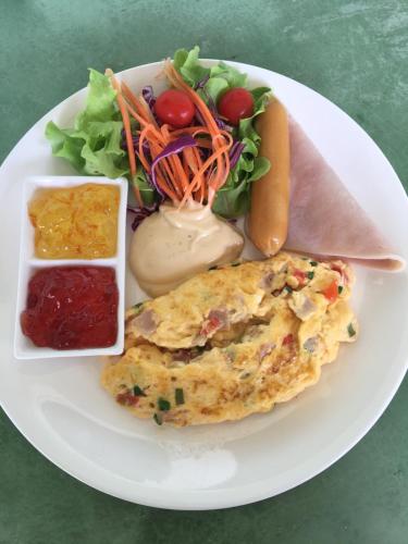een bord eten met een omelet en een salade bij The Herbal Khao Lak in Khao Lak
