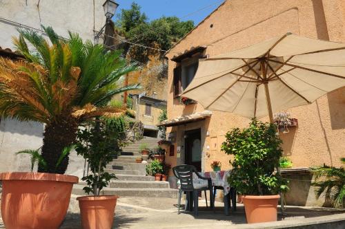 a table with an umbrella in front of a building at La Casa Del Sole in Bomarzo