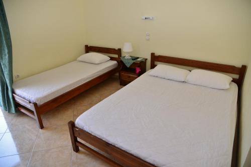 Habitación con 2 camas y mesa auxiliar en Studios Elpida, en Tyros